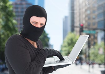 Poster - Criminal Man in balaclava on laptop in front of city