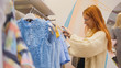 © KONSTANTIN SHISHKIN - Attractive girl in a fashion dress store chose a clothe - fashion shopping