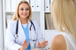 © rogerphoto - Doctor reassuring her female patient. Medicine, help and health care concept.