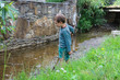 Small boy near narrow creek in city park