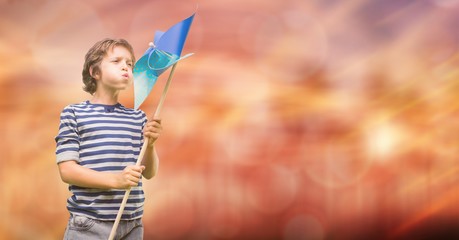 Poster - Boy blowing pinwheel over bokeh