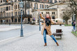 © EdNurg - Funny Woman in warm clothes posing and dancing on the old city street