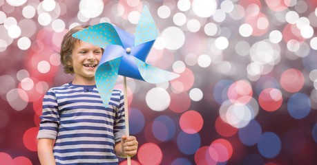 Poster - Happy boy holding pinwheel against bokeh