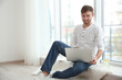 © Africa Studio - Handsome young man with laptop at home