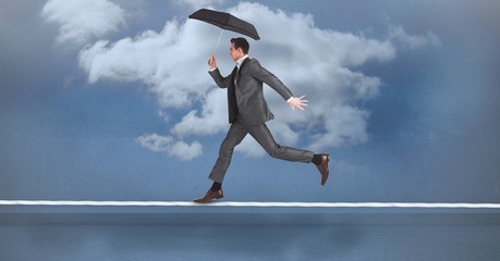 Poster - Businessman with umbrella running on rope against sky