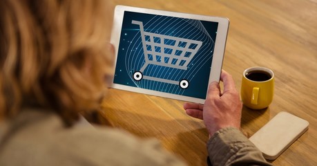 Poster - Woman looking at shopping cart icon on tablet PC