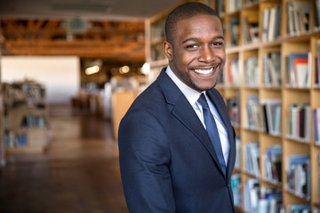 Education administrator faculty member standing in university hall library with nice smile