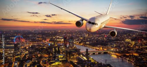 Fotografía Passengers airplane flying above London city in the sunset light
