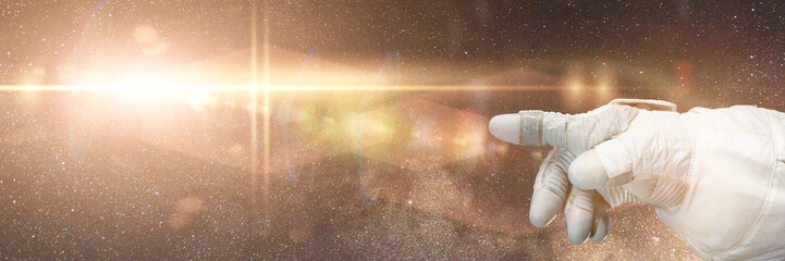 Wall Mural - astronaut pointing to a bright star in front of the milky way galaxy