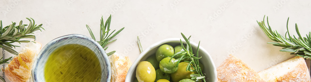 Olivier oil with fresh herbs and bread. Light background. Italian and Greek national food. Top view - obrazy, fototapety, plakaty 
