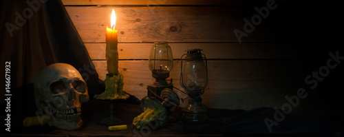 Skull With Candles And Barn Lanterns On Black Cloth And Old Wooden