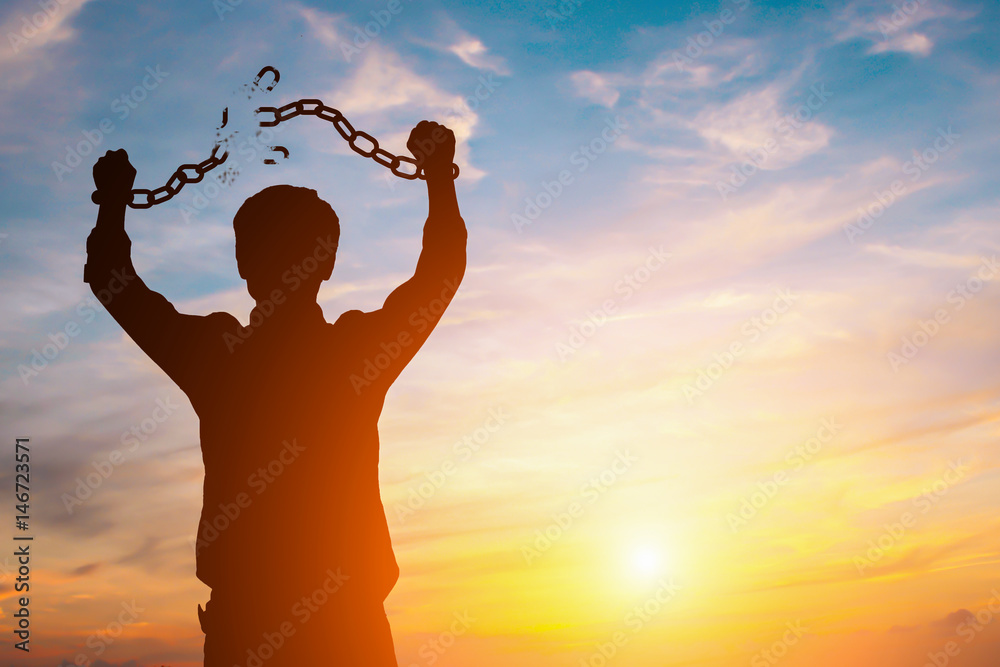 Silhouette image of a businessman with broken chains in sunset - obrazy, fototapety, plakaty 