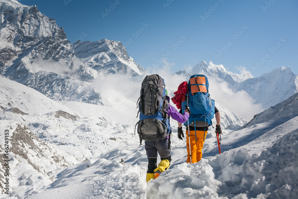 Trekkers crossing Gokyo glacier in Khumbu valley on a way to Everest Base camp - obrazy, fototapety, plakaty 