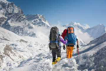 trekkers crossing gokyo glacier in khumbu valley on a way to everest base camp