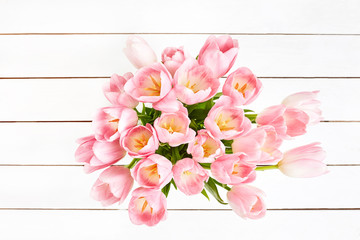 Bouquet of pink tulips on white wooden table. Top view, copy space