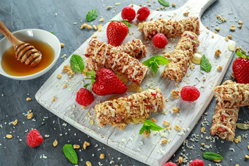 Wall Mural - Granola bar with strawberries, raspberry honey and white chocolate on cutting board