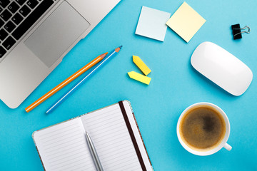 Poster - Start of Morning work office desk with a cup of coffee computer laptop, notebook, pen,  blue texture table. Business concept background