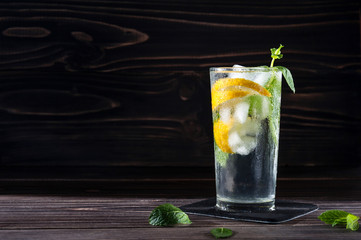 Lemonade with fresh lemon on wooden background