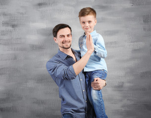 Poster - Handsome man and his son near color wall