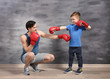 © Africa Studio - Father and son during boxing training near color wall