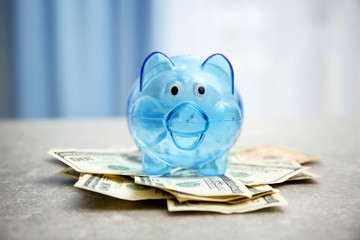 Wall Mural - Piggy bank and dollar banknotes on table