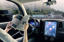 Cockpit Of Autonomous Car. A Vehicle Running Self Driving Mode And A Woman Driver Reading A Book.