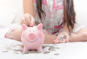 Wall Mural - girl hand put money to piggybank on bedroom