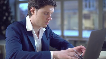 Poster - Portrait handsome caucasian man using laptop. Young businessman chatting online or buy some purchases or download book.