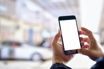 Businessman using smartphone over blurred garage car service center background. For Graphic design montage.
