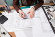 © DC Studio - Close up of architect hands working on blueprints. Business and creativity. Architecture job