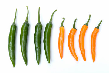 Top view green and orange chili pepper on white background isolated.