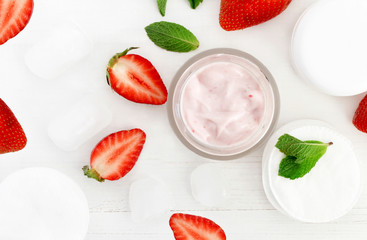 Skincare food facial mask homemade fresh strawberry and mint in jar, bright red berries, organic botanical beauty treatment  ingredients on white wooden background top view.
