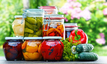 Jars Of Pickled Vegetables And Fruits In The Garden