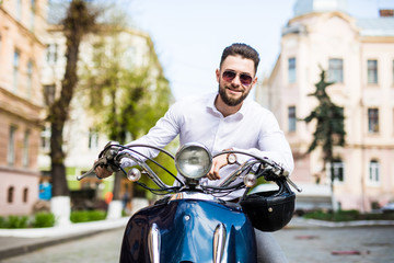 Handsome young man while sitting on scooter