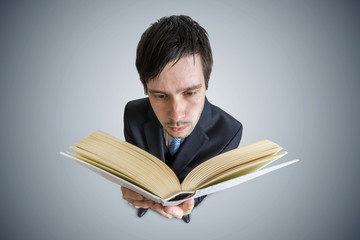 Young man is reading a book. View from above.