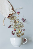 Fototapeta  - Tea time. Dry herbal tea and cup on the gray background, top view
