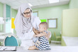 Muslim pediatrician examining little baby