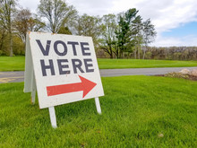 Wooden Vote Sign On Grass With Red Arrow