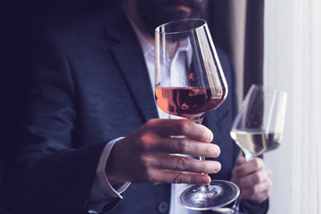 man offering a glass of rose wine