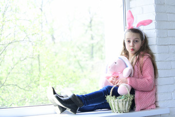 baby girl in easter bunny ears with plush rabbit toy