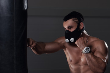 Young muscular man boxing in high altitude mask