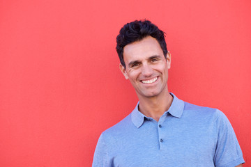 Wall Mural - Close up handsome man smiling against red background