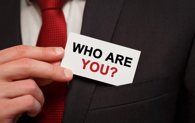 Poster - Businessman putting a card with text Who are you in the pocket