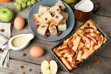 Wall Mural - Freshly baked bread pudding in casserole dish and ingredients on wooden table