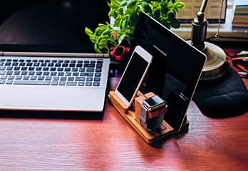 Communication set with wooden stand, smart watch, tablet PC and smart phone.