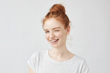 Poster - Young playful beautiful girl with foxy hair smiling winking looking at camera. Isolated on white background. Upbeat