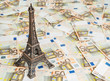 Travel budget concept with copy space. Eiffel Tower souvenir and vacation money. Savings for trip to France. 