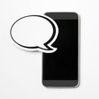 Blank speech bubble on a grey empty screen smartphone. Paper speech balloon and mobile phone. Perfect for website, social media, offer and promotion. Plenty of free copy space for your own text. 