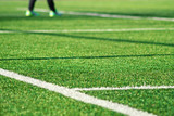 Fototapeta Sport - Artificial green grass with white stripe of soccer field