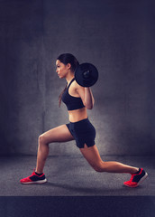 Poster - young woman flexing muscles with barbell in gym